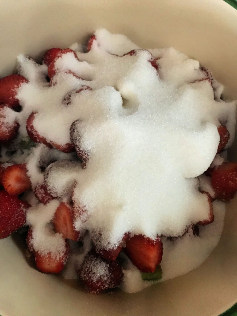 sugar on top of fruit in a saucepan
