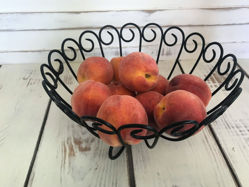 peaches in a black metal bowl